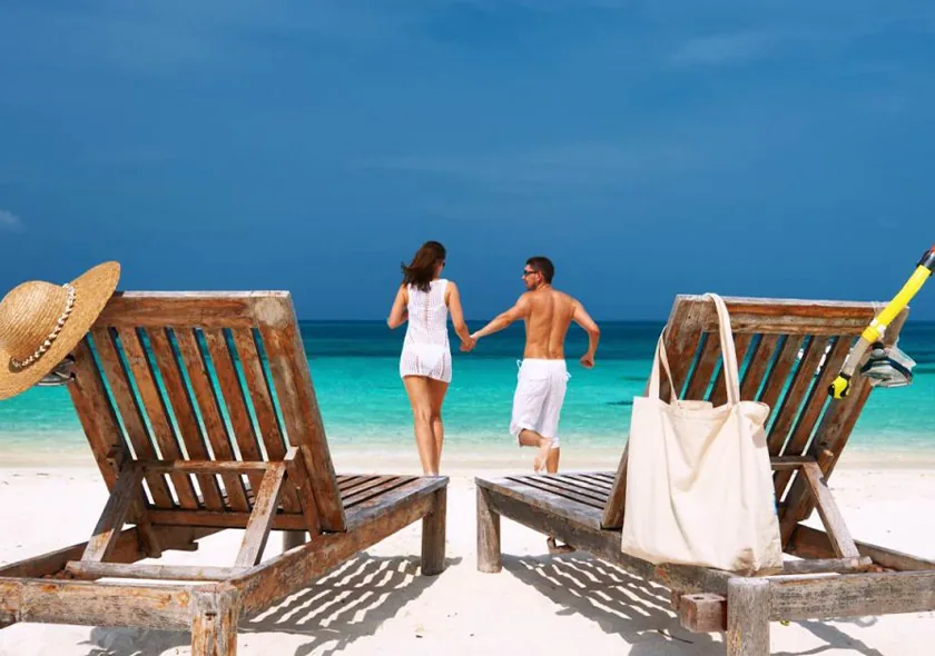 Couple walking towards the turquoise sea on a Zanzibar beach